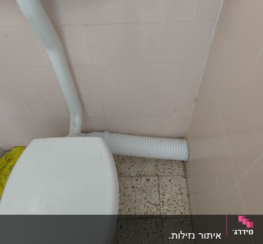 אסלה וצינור ניקוז שרשורי בחדר רחצה ביתי